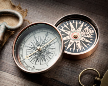 Two compasses on a table.